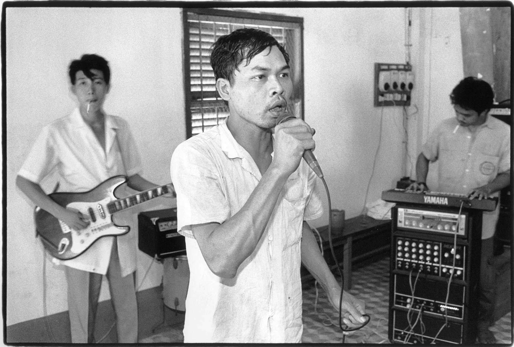 Vietnam, psychiatry and war.  Patients sing, accompanied by nurses, during musical therapy in Bien Hoa Mental Hospital. The instruments are gifts from family of patients and nurses, now living in the USA. Part of the patients are suffering from war traumas.